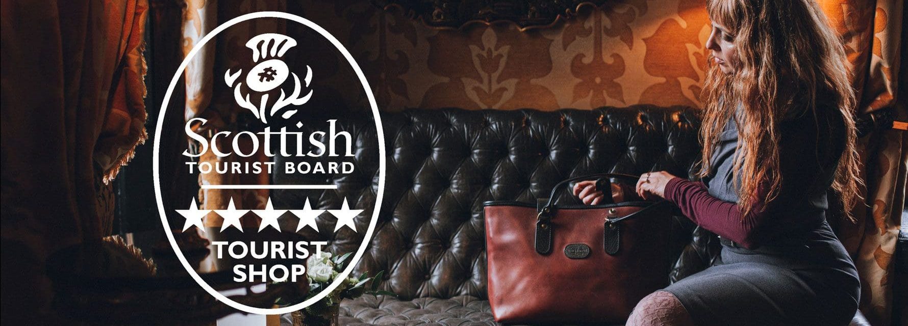 A 5 Stars Tourist leather Shop by Visitscotland in Edinburgh. Mackenzie Leather's Creative Director, Elena Alvarez showing a leather Business Tote proudly with the earned award.